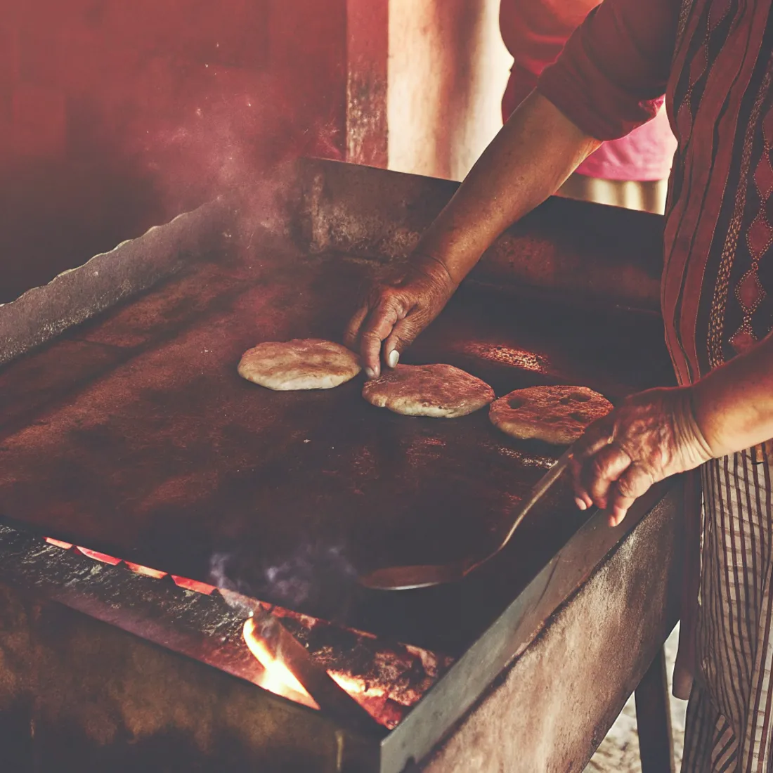A shared Salvadoran meal being prepared over an open flame